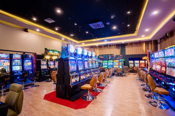Uma mulher glamourosa segurando fichas de cassino em um ambiente iluminado por néon, representando a atmosfera premium do cassino online LINDTT.